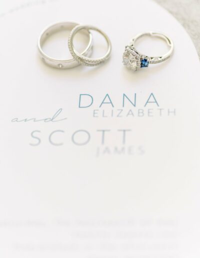 Three rings on a paper with the names "DANA ELIZABETH and SCOTT JAMES.