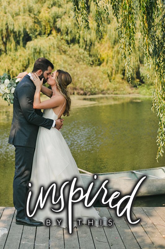 A bride and groom kiss on a wooden dock by a lake with a rowboat and trees in the background; the text "inspired by this" overlays the image.