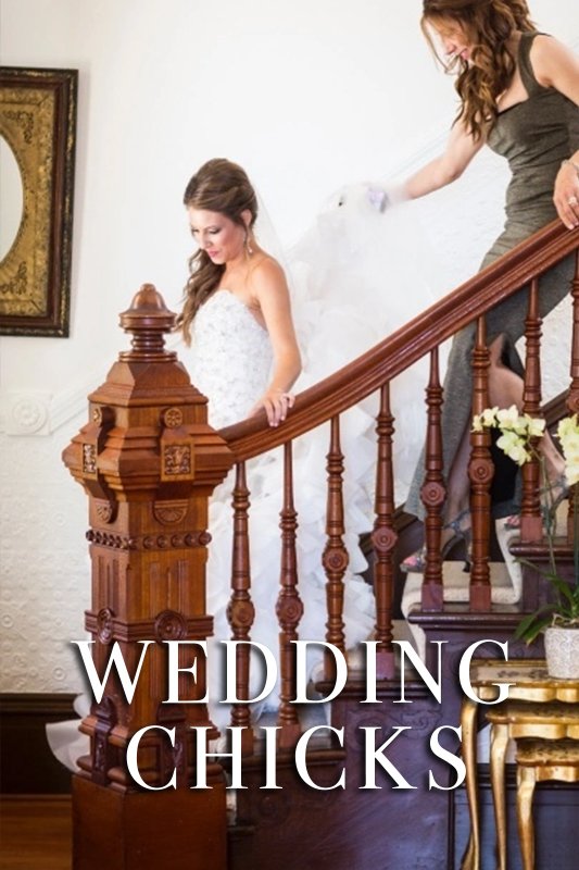 A bride descends a wooden staircase while another woman assists with her dress, overlaid with the text "WEDDING CHICKS.