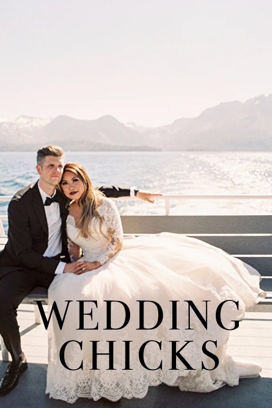 A bride and groom sit on a bench with a scenic mountain and lake backdrop. The bride wears a white dress, and the groom is in a suit. Text overlay reads "WEDDING CHICKS.