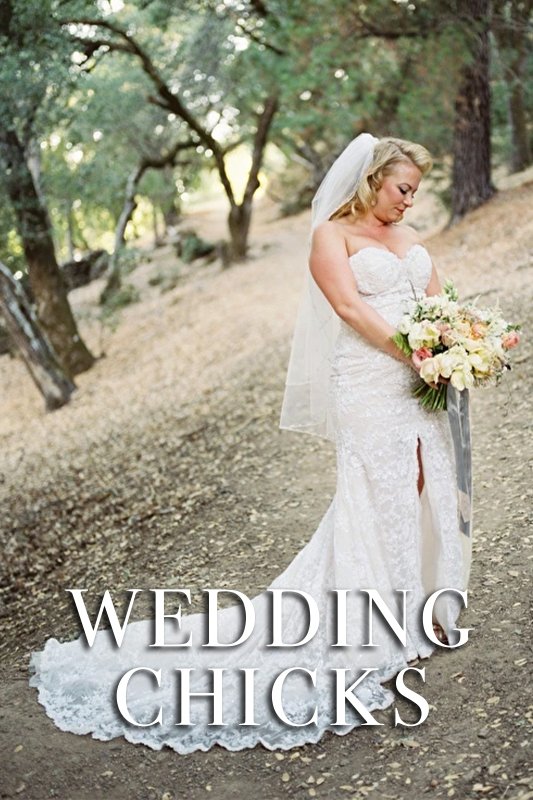 A bride in a white lace gown with a long train stands on a leaf-strewn path holding a bouquet. The text "WEDDING CHICKS" is overlaid on the image.