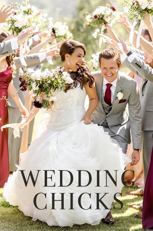 A couple in wedding attire walk joyfully under an arch of raised hands held by guests. Text overlay reads "WEDDING CHICKS.