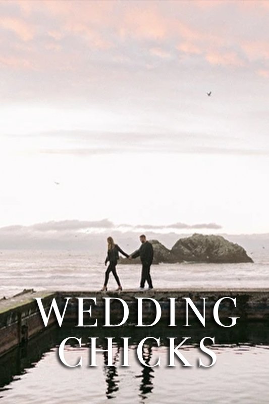 A couple holding hands walks along a dock by the water with the text "WEDDING CHICKS" overlayed at the bottom of the image.