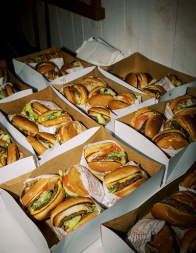 Rows of boxed burgers with lettuce, tomato, and beef patties.