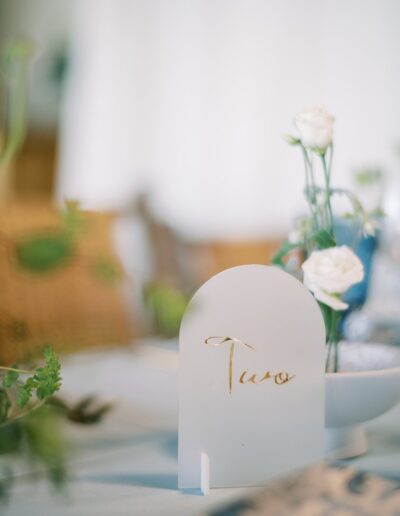 Table decor with small white flowers and a card displaying the number two.