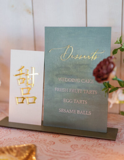 Menu card listing desserts: wedding cake, fresh fruit tarts, egg tarts, sesame balls. Decorative gold text and floral accents.