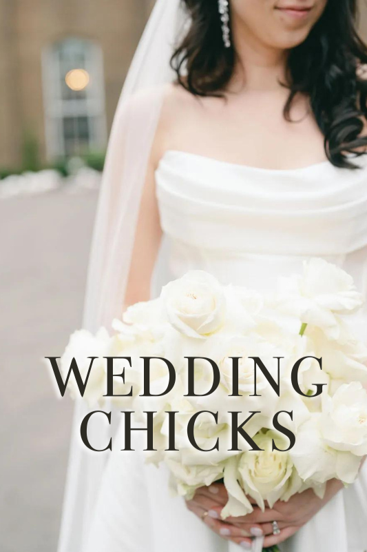 Bride in a white wedding dress holds a bouquet of white roses.