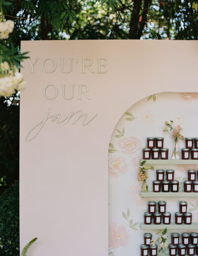 A display wall titled "You're Our Jam" holds shelves of small jam jars. The background features floral designs.