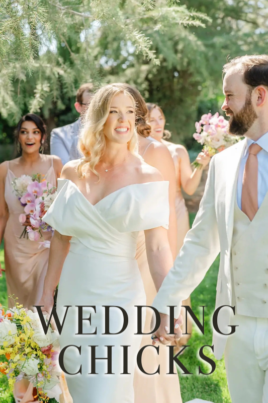 A bride in a white off-the-shoulder gown holds hands with the groom, accompanied by bridesmaids in pink dresses, outdoors on a sunny day. Text reads "WEDDING CHICKS.